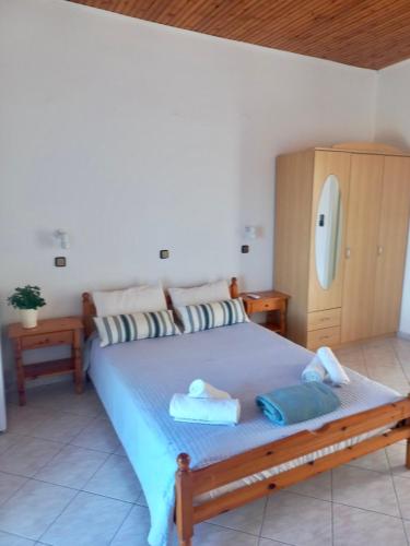 a bedroom with a large bed with towels on it at Petalides Studios in Livadáki