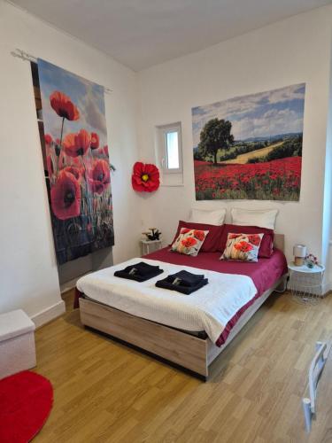 a bedroom with a large bed with red flowers on the wall at Le Sixty in Saint-Gaudens