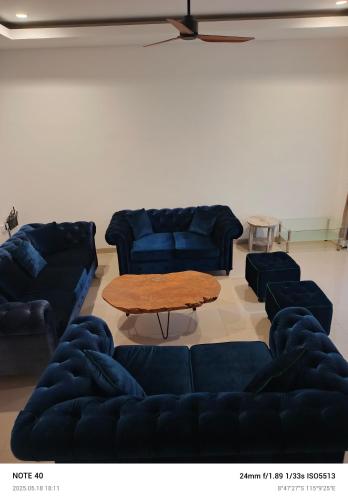 a living room with blue couches and a table at Lucky Villa Jimbaran Penta in Jimbaran
