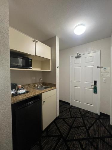 a small kitchen with a sink and a door at Quality Inn & Suites Loveland in Loveland