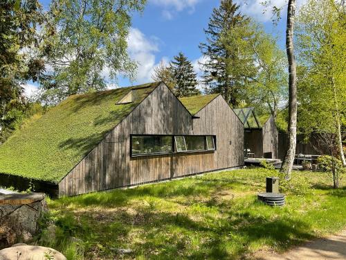 een houten huis met een grasdak bij Architect-Designed House Close To Hornbæk in Tikøb