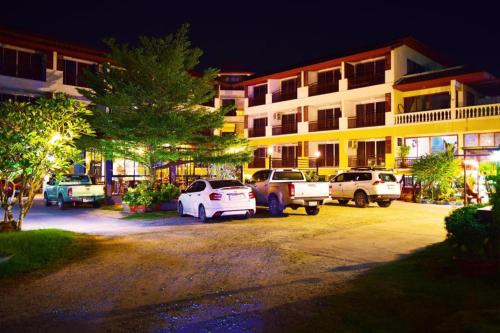 a parking lot in front of a building at night at Nantharom Hotel and Restaurant in Chachoengsao