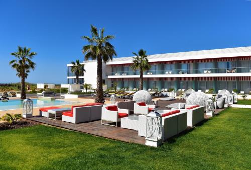 a resort with a pool and tables and chairs at Pestana Alvor South Beach Premium Suite Hotel in Alvor