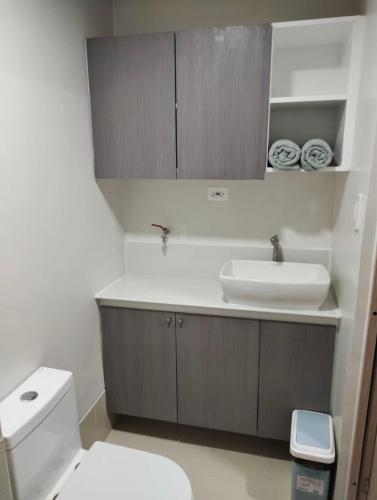 a bathroom with a white toilet and a sink at Unit A-1607 Style Residences in Iloilo City