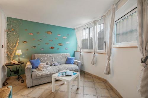 un salon avec un canapé et un mur de poissons dans l'établissement Sea Breeze Garavan Apt Villa New York - Happy Rentals, à Menton