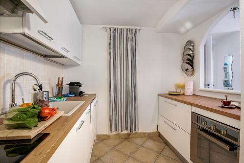 - une cuisine avec un évier et un comptoir avec des légumes dans l'établissement Sea Breeze Garavan Apt Villa New York - Happy Rentals, à Menton