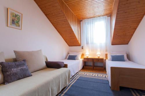 a room with two beds and a couch and a window at Apartments Matijasevic in Korčula