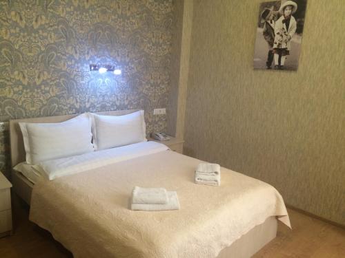 a bedroom with a bed with two towels on it at Hotel Doesi in Tbilisi City