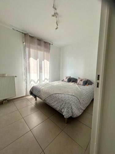 une chambre avec un lit dans une pièce blanche dans l'établissement Villa lumière, à Cannes