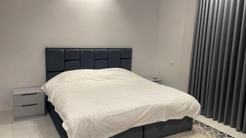 a bedroom with a large bed with white sheets at شقة بغرفة نوم وصالة - Luxury bedroom and living Room in Jeddah