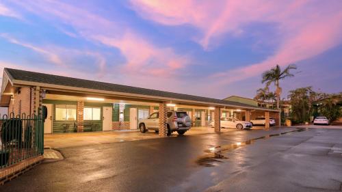 a building with a car parked in a parking lot at Best Western Cattle City Motor Inn in Rockhampton