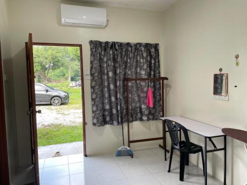 a table and chair in a room with a window at Motel Santai Bandar Pekan in Pekan
