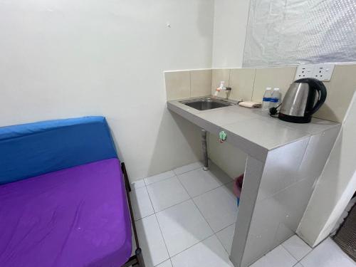 a small bathroom with a sink and a table at Motel Santai Bandar Pekan in Pekan