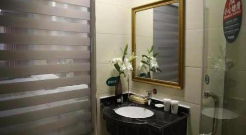 a bathroom with a sink and a mirror at GreenTree Inn Anhui Bozhou West Guangming Road Tangwang Avenue Shall Hotel in Bozhou