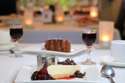 a piece of cake on a plate with two glasses of wine at Best Western Cattle City Motor Inn in Rockhampton