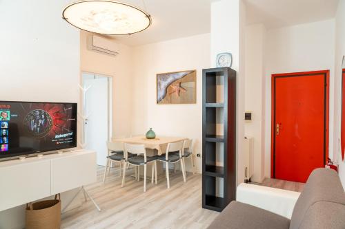 a living room with a red door and a table at Accesso al mare, residence perseo in Lido Adriano