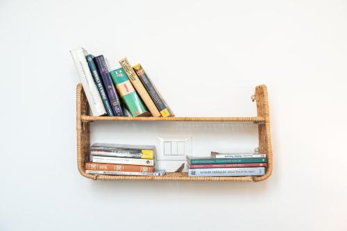 a book shelf filled with books on a white wall at Accesso al mare, residence perseo in Lido Adriano