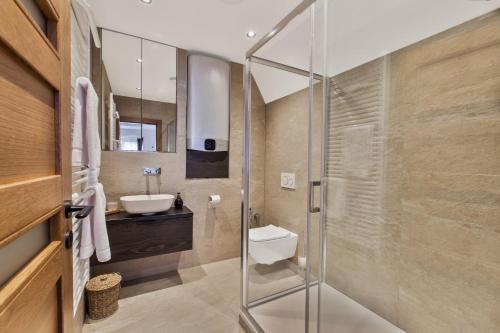a bathroom with a glass shower and a sink at Brezno Central Apartments in Brezno