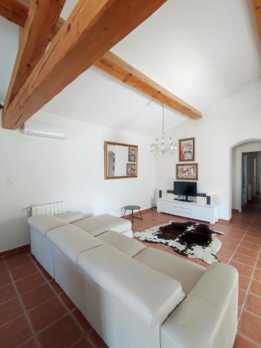 - un salon avec des canapés en cuir blanc et une table dans l'établissement Charmante villa proche Uzès, à Saint-Quentin-la-Poterie