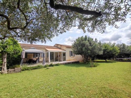 une maison avec une pelouse devant dans l'établissement Charmante villa proche Uzès, à Saint-Quentin-la-Poterie