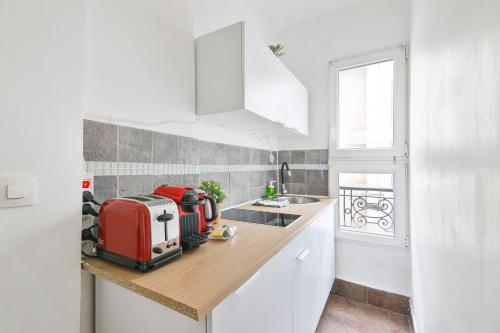une cuisine avec un appareil rouge sur un comptoir dans l'établissement Heart of Paris-1BR-4P-Tour Eiffel 8 -Free Netflix, à Paris