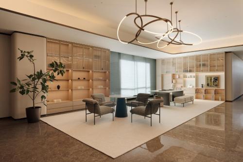 a large kitchen with a table and chairs and a chandelier at Mlily Hotel in Shanghai