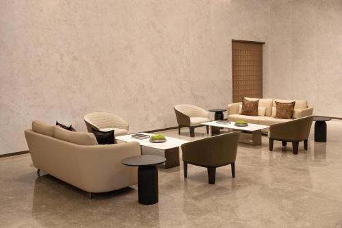 a living room with couches and tables and chairs at Mlily Hotel in Shanghai