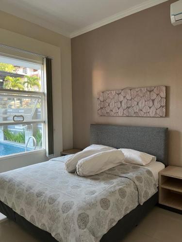 a bedroom with a bed and a large window at Gandaria Villa Batu in Batu
