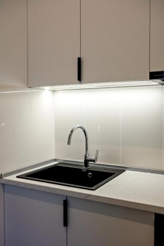 a kitchen counter with a sink and white cabinets at DilijanInn Hotel and Restaurant in Dilijan