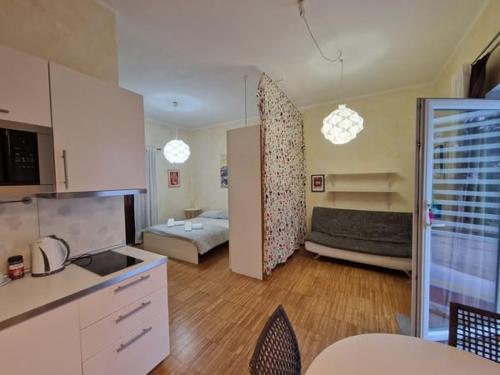 a room with a kitchen and a living room with a couch at Residence Bed&Bike in Moggio Udinese