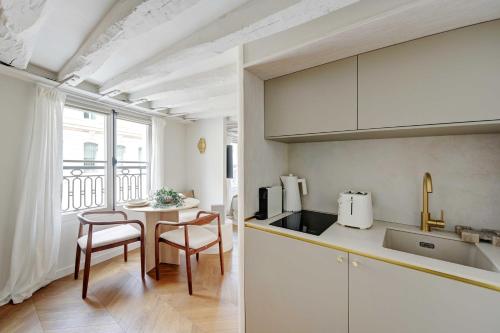 une cuisine et une salle à manger avec une table et des chaises dans l'établissement Magnificent studio - 2P- Musée du Louvre, à Paris