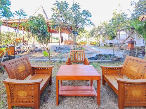 a table and chairs with a wooden table and benches at Pondok Daun D Martin Mitra RedDoorz near UMY in Ngingas