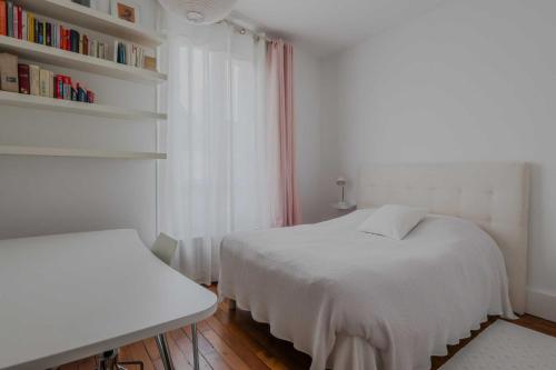 - une chambre blanche avec un lit et une étagère dans l'établissement Magnificent apartment- 2BR 4P- Near Sacré-Cœur, à Paris