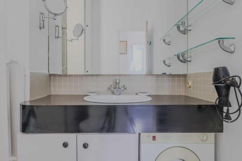 une salle de bain avec un lavabo et une machine à laver dans l'établissement Magnificent apartment- 2BR 4P- Near Sacré-Cœur, à Paris