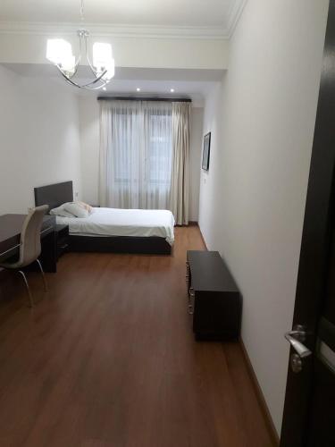 a bedroom with a bed and a desk and a table at Avenue apartments in Yerevan