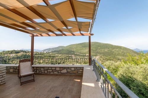 d'un balcon avec une chaise et une vue sur les montagnes. dans l'établissement Odyssey's Palace - Escape in Mythical Ithaca, à Platithriás