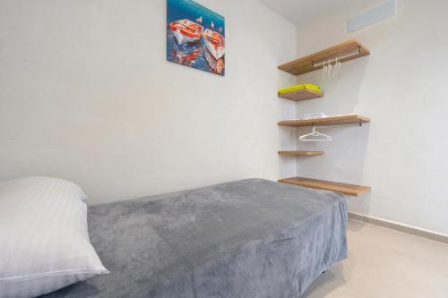 a white bedroom with a bed and shelves at Eucaliptus in Camarles