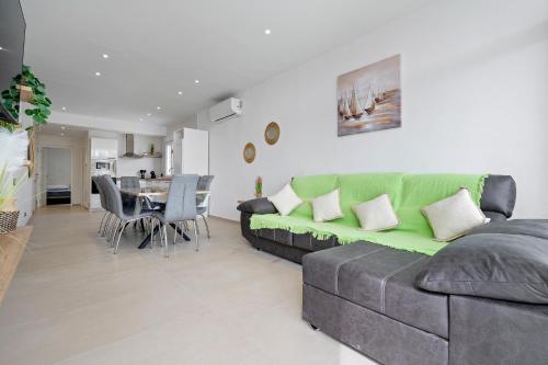 a living room with a green couch and a table at Eucaliptus in Camarles