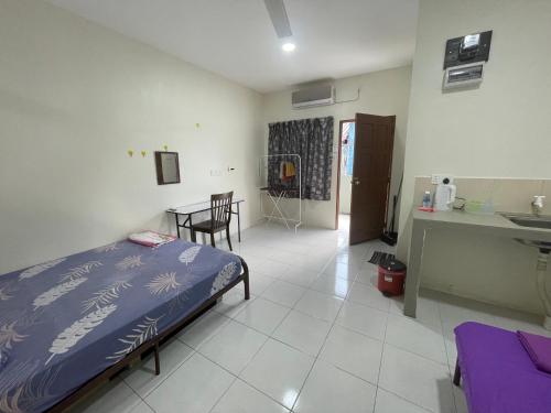 a bedroom with a bed and a kitchen and a table at Bilik Rehat Aircond Pekan in Pekan