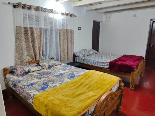a room with two beds in a room at Doddagadde Stays - Near to Ettina Bhuja trekking in Mudigere