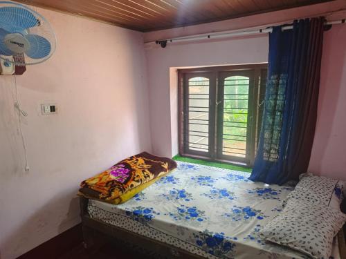 a small bedroom with a bed and a window at Doddagadde Stays - Near to Ettina Bhuja trekking in Mudigere