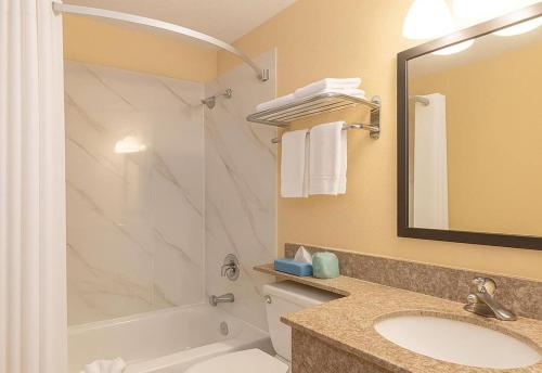 a bathroom with a shower toilet and a sink at Travelodge by Wyndham Muskegon in Muskegon