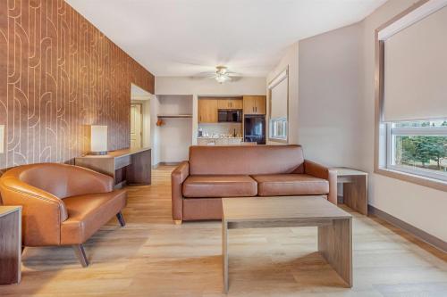a living room with a couch and a table at Days Inn & Suites by Wyndham West Edmonton in Edmonton
