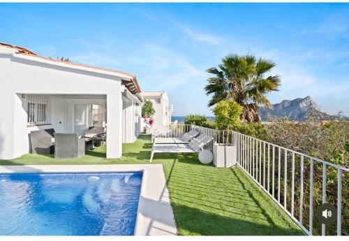 a villa with a swimming pool and a garden at Espectacular villa junto a la playa, piscina privada y vistas al mar in Calpe