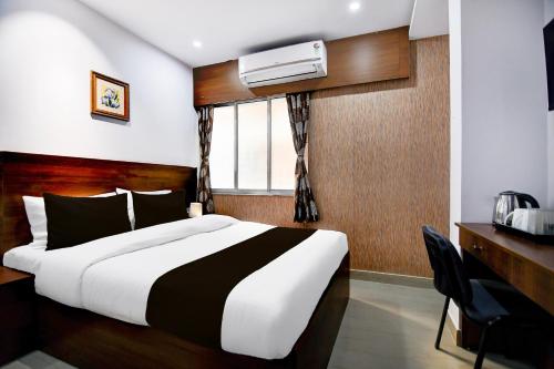 a bedroom with a large bed and a window at Super Collection O Chinar Park Near Airport in Kolkata