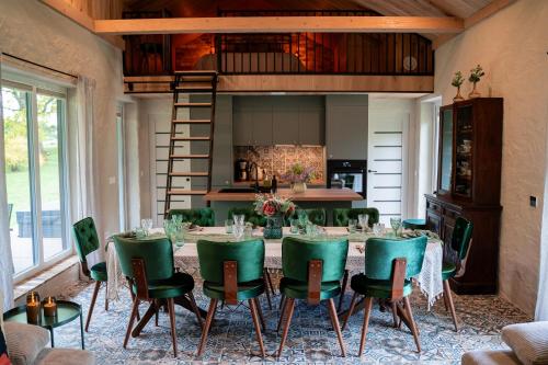 a dining room with a table and green chairs at Pramogų namelis 