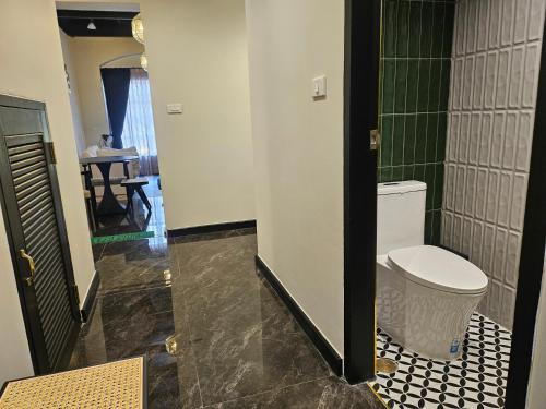 a bathroom with a toilet and a black and white floor at Soho House Old Town Bangkok in Bangkok