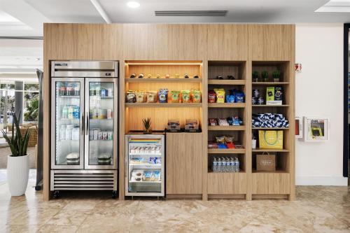 a refrigerator and shelves with food in a room at GALLERY One - A DoubleTree Suites by Hilton Hotel in Fort Lauderdale