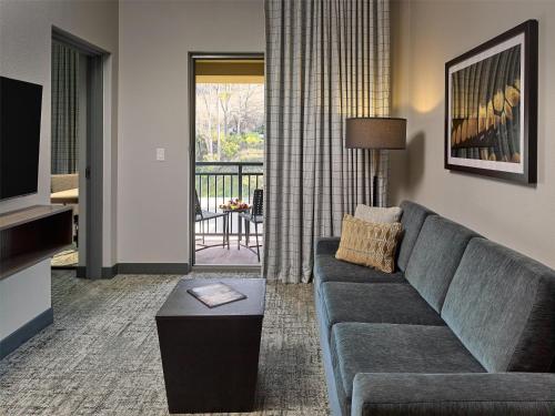 a living room with a couch and a television at Embassy Suites By Hilton Gatlinburg Resort in Gatlinburg