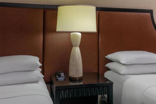 a lamp sitting on a table next to two beds at Courtland Grand Hotel, Trademark Collection by Wyndham former Sheraton Atlanta in Atlanta